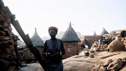 Dogon woman with ladder leading to rooftop