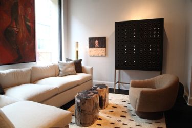 Petrified wood tables placed on top of an antique Moroccan rug amid sleek contemporary furnishings