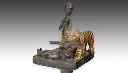 Linguist staff depicting tiger and hunters