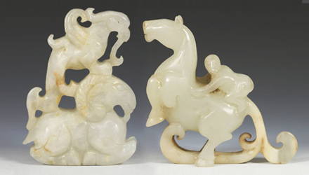 Two jade toggles, one depicting a figure of a monkey on a horse, the other a phoenix on a ram