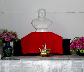 A humble shrine complete with a cigarette incense burner illustrates Mao elevated to the level of a deity. Photo taken in Northern China, 2003
