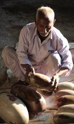 A local villager with his collection of polished lingams