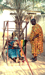 Asante weaver with man wearing kente clothing