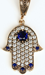 This stylized hand, known as the Hamsa, is adorned with sapphires and diamonds This stylized hand, known as the Hamsa, is adorned with sapphires and diamonds