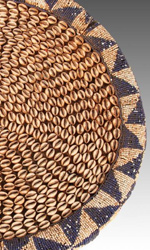 This carved stool is covered in thousands of glass beads and cowrie shells