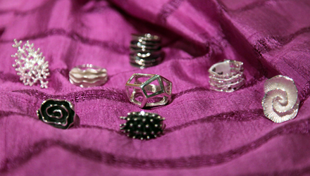 Contemporary Ssterling silver rings featuring designs that include the heart of a seashell, a cosmic star cluster, the ingenuity of a geodesic dome