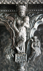 A Deva chased in silver over teakwood 