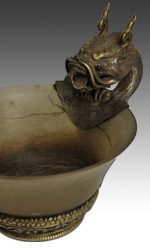 The teacup is fitted with a carved and gilded silver base and handle