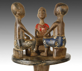 Linguist's staff depicting 3 seated figures
